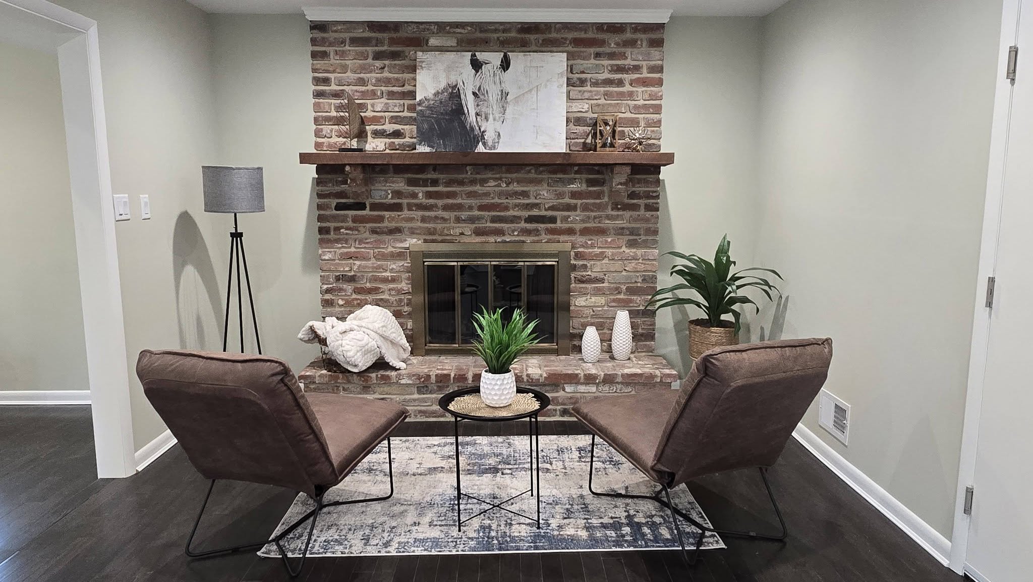 Exposed brick fireplace with glass doors and wood mantel in a Vermont home serviced by Mad River Valley Chimney Services