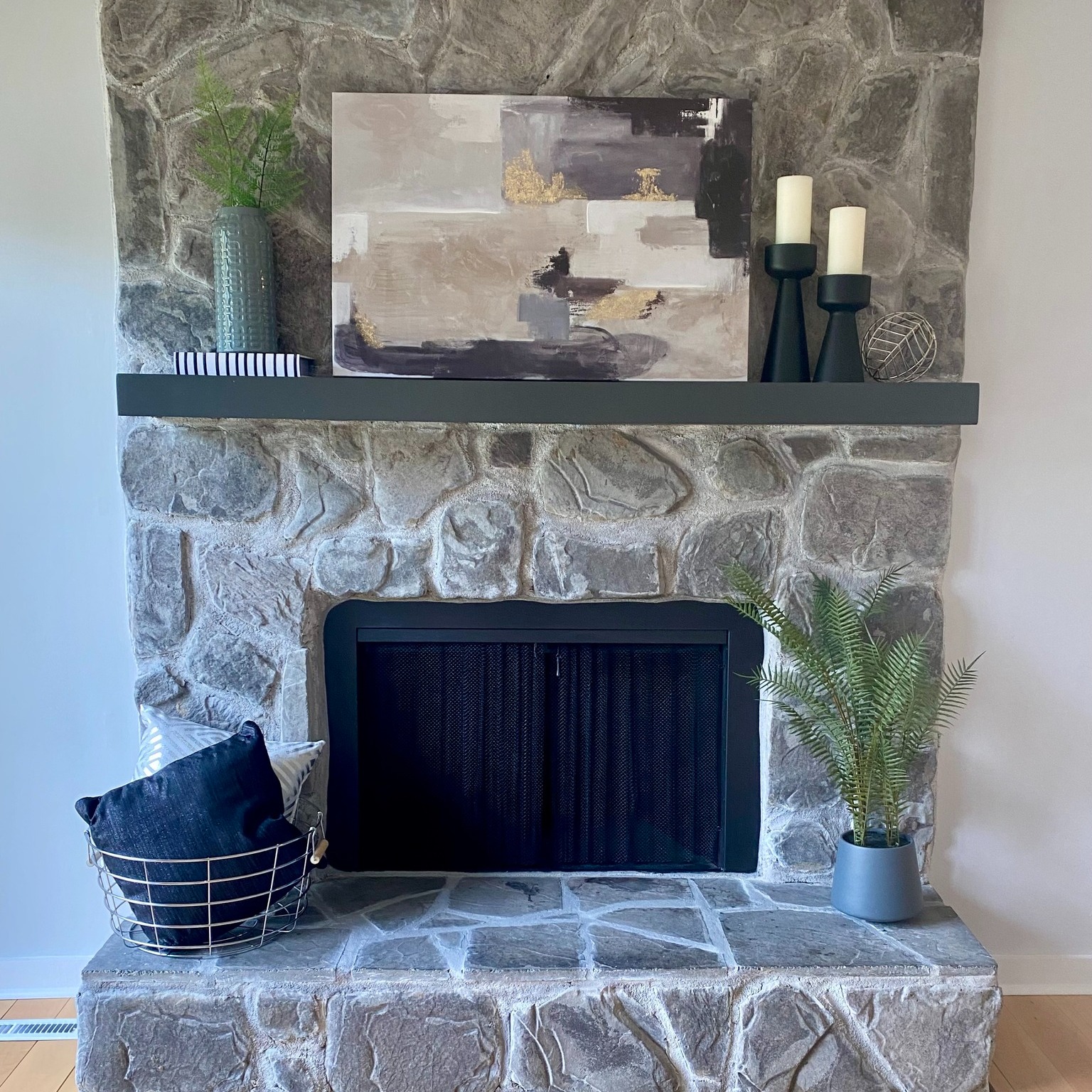 Fieldstone masonry fireplace with mesh screen and modern mantel shelf in a Vermont home inspected by Mad River Valley Chimney Services