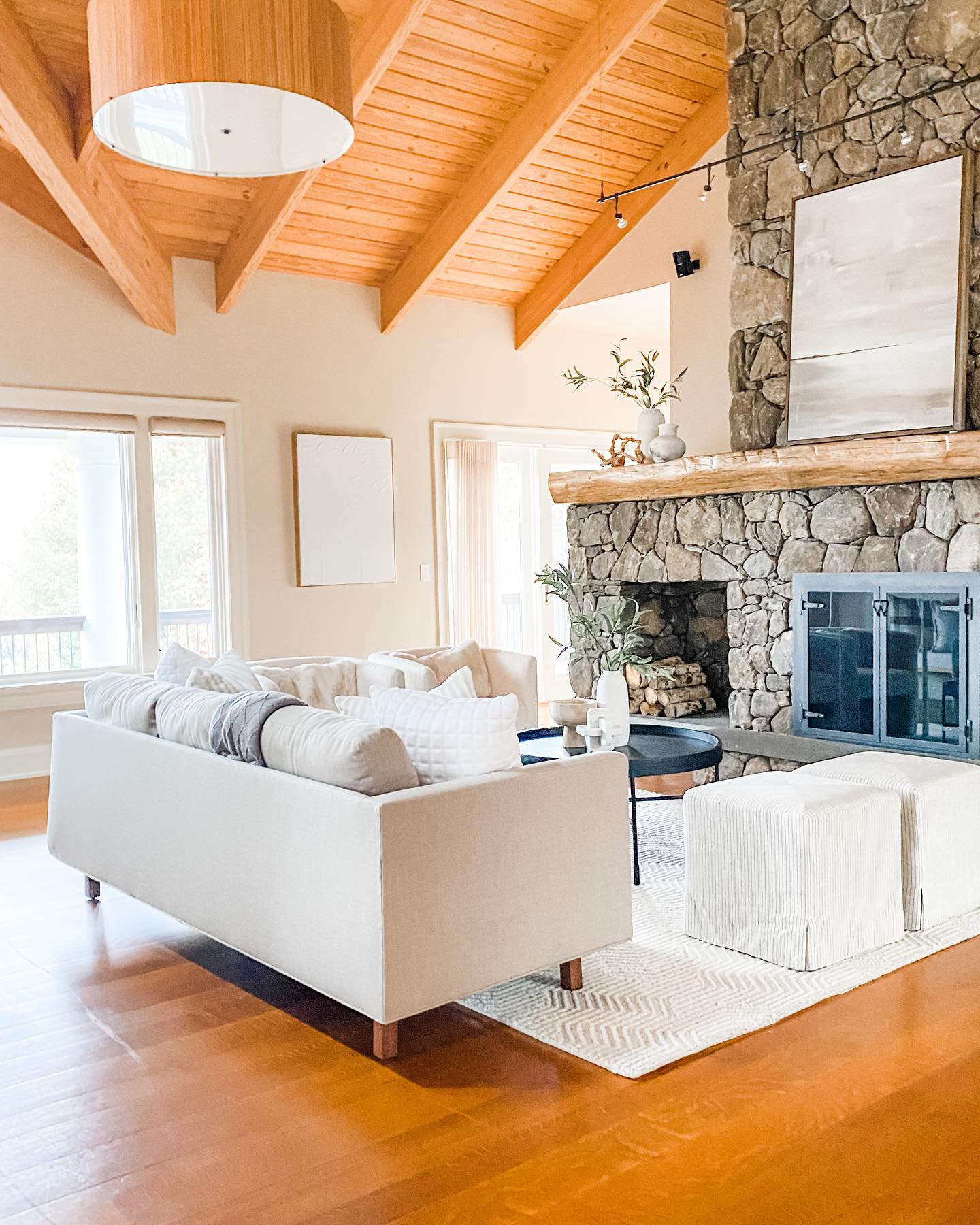 Stone fireplace with log mantel in a Vermont vacation home with cathedral ceilings serviced by Mad River Valley Chimney Services in Warren VT